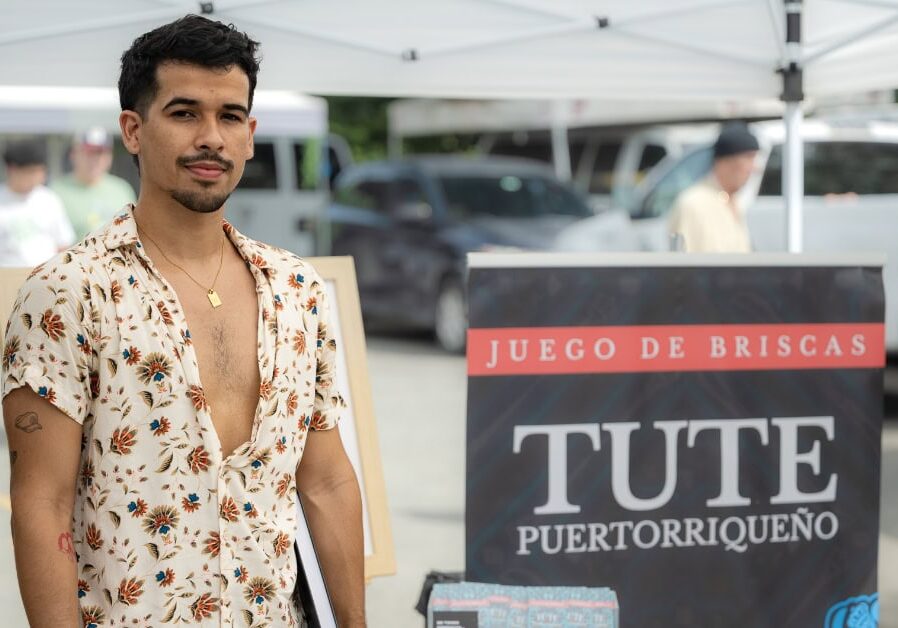 Kevin Mejías being interviewed about Tute Puertorriqueño at a local market
